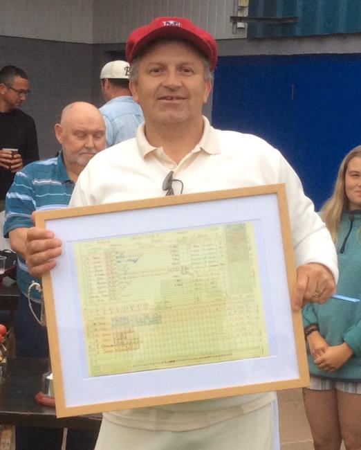 Ollie Cook and his framed scored of his 100 against Kilgetty