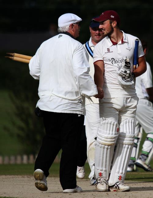 Century maker Iwan Izzard congratulated by umpire Trefor Evans