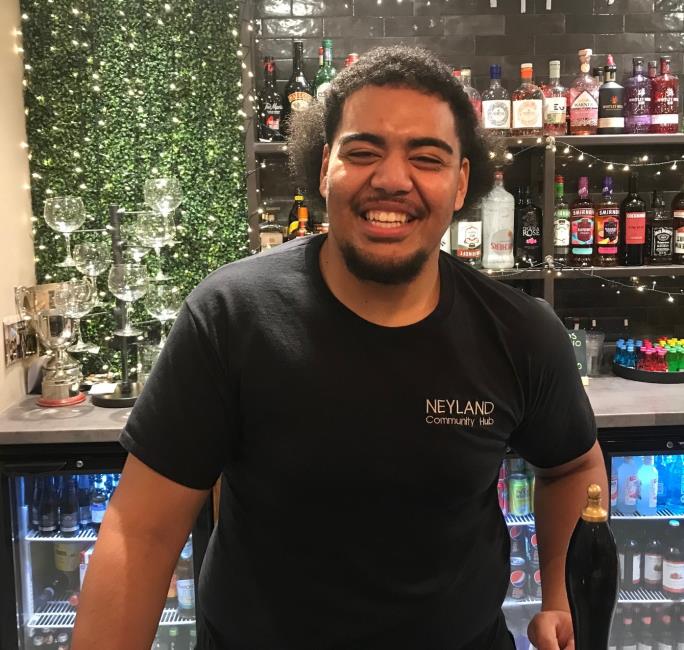 A smiling Ebs behind The Hub bar