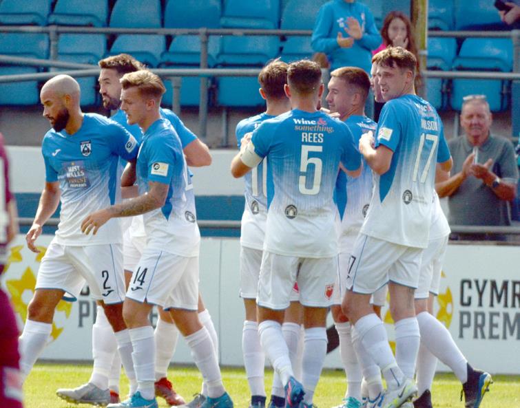 Players surround goal scorer Henry Jones