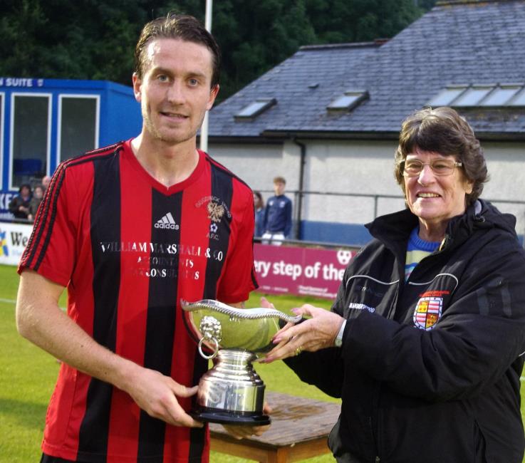 Goodwick United skipper Kieran O Brien receives Jubilee Cup off League chairperson Rowenna Lloyd