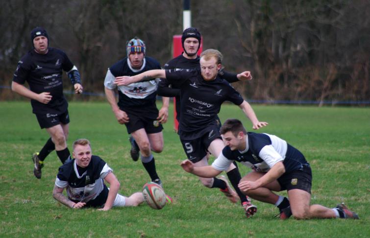Neyland scrum half Adam Cawley kicks ahead against the Quins