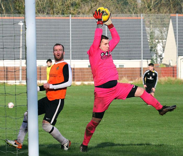 Pennar Robins goalkeeper Stuart James cuts out a cross at Bush Camp