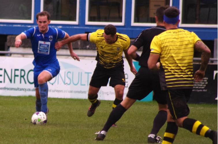 Left back Kristian Speake looks for a way through the tight Wellmen defence