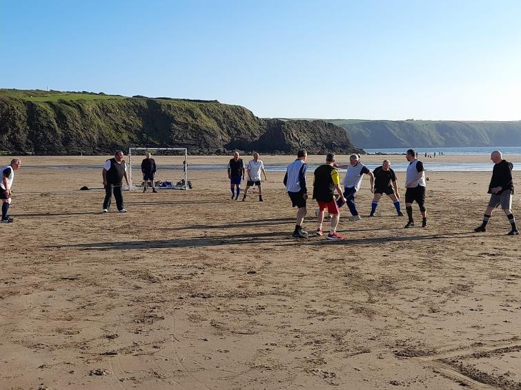 Walking footballers playing on the beach