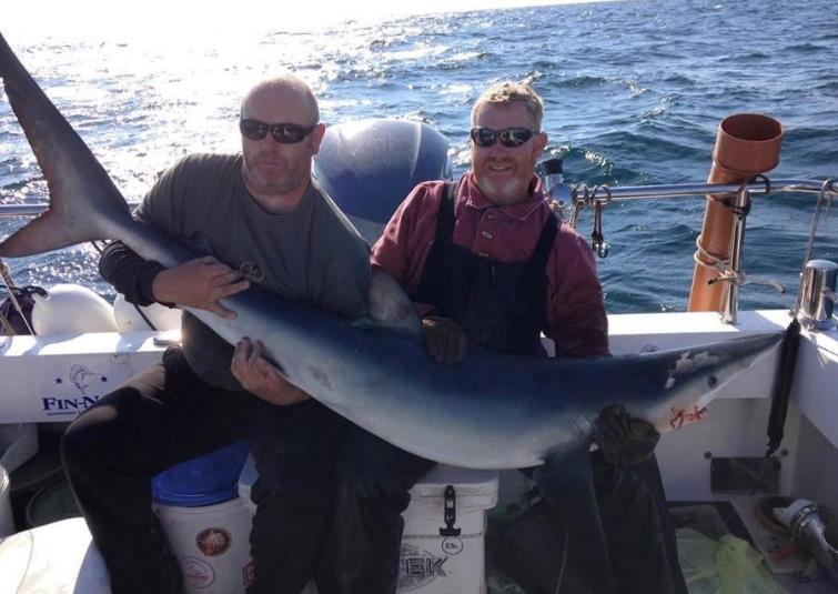 Tom holds on to his monster fish with boat skipper Rob Rennie